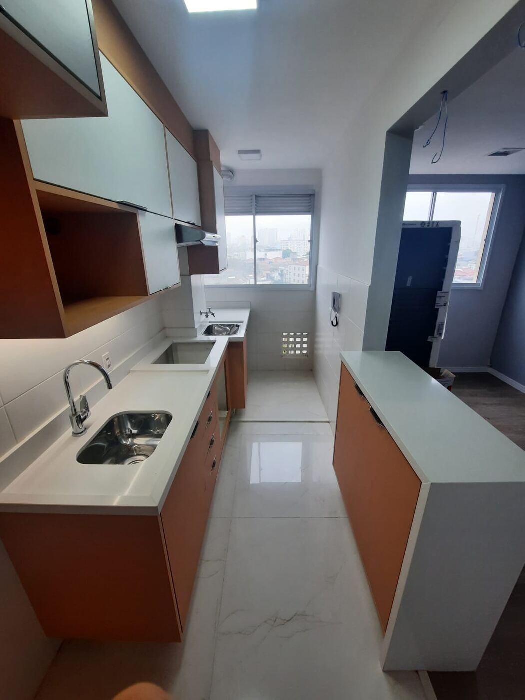 Cozinha planejada em corredor, com bancada em pedra