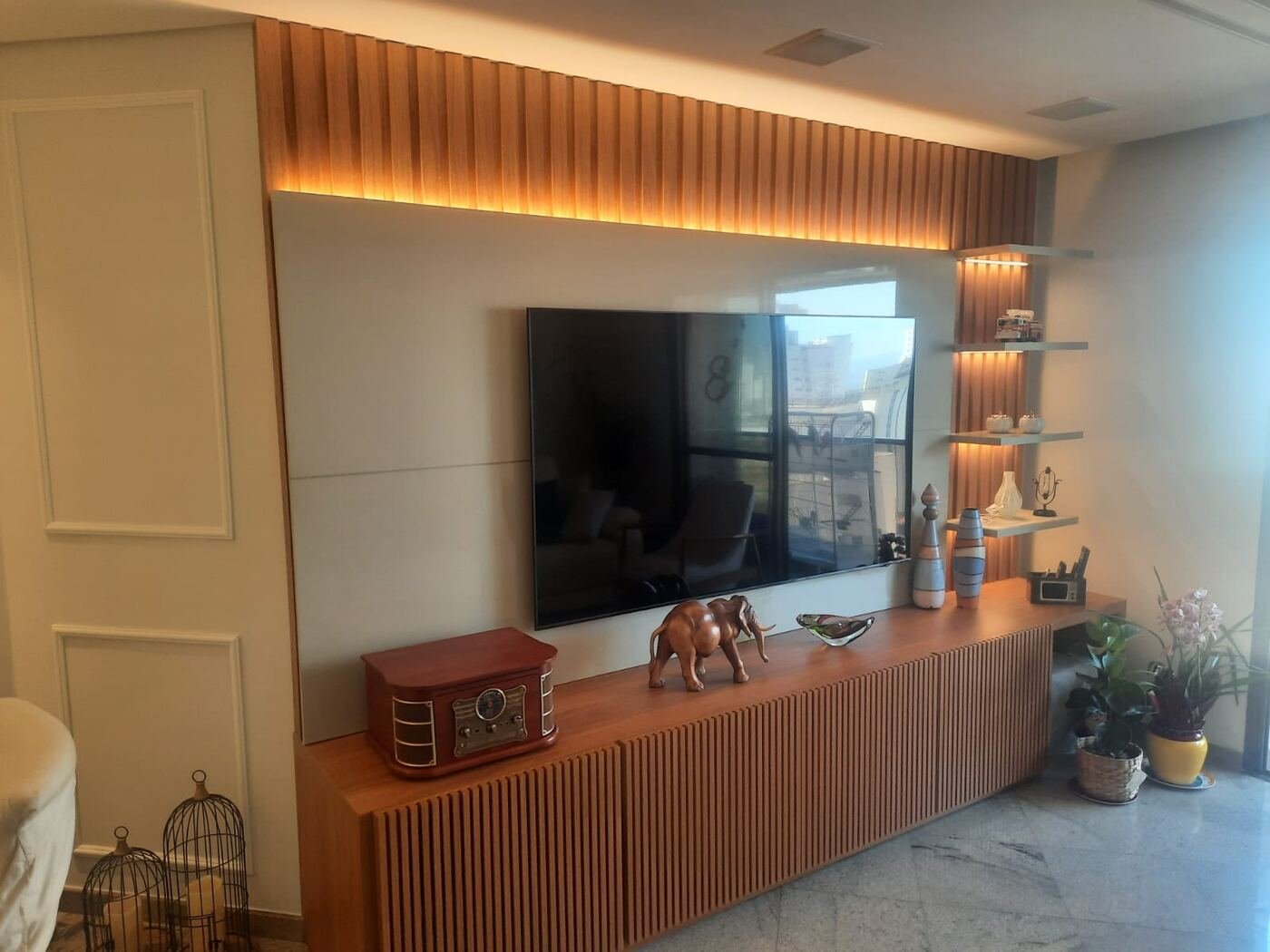 Painel de TV planejado em madeira, com iluminação embutida